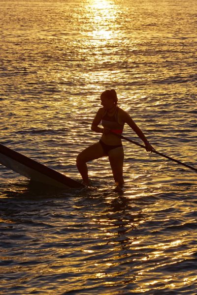 SUP Stand up Surf girl with paddle at sunset